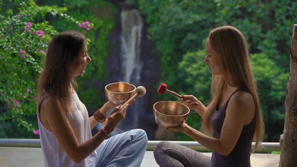 Superslowmotion Shot of a Woman Master of Asian Sacred Medicine Performs Tibetan Bowls Healing