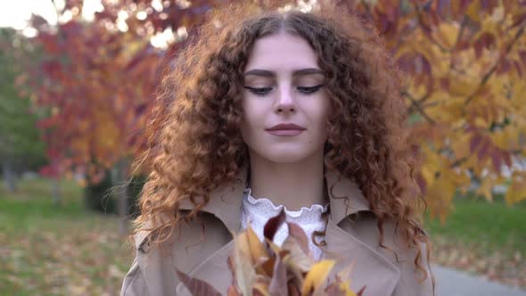 Beautiful Woman Throws Up Fallen Leaves