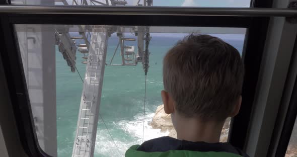 Boy looking at sea from moving funicular in Rosh Hanikra