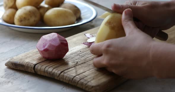 A woman is peels vegetables