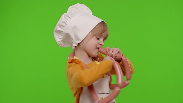 Teen Child Girl Dressed As Cook Chef in Apron Dancing with Sausages Fooling Around on Chroma Key