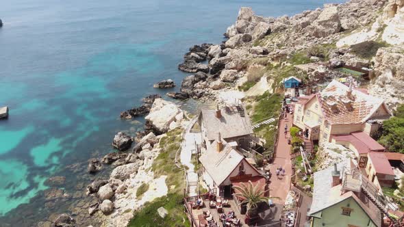 Popeye Village in Anchor Bay, also known as Sweethaven Village, Malta.  Aerial forward 