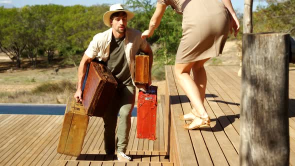 Woman helping the man in carrying suitcase 4k