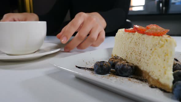 Male Hands Putting White Plate with Cake on Table in Front of Female Guest. Waiter Serving Dessert