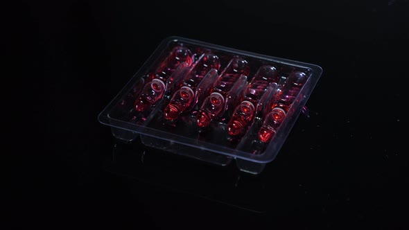 Vaccine ampoules with medicine on black background, close-up