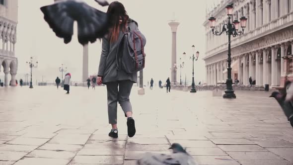 Happy Female Photographer with Camera Walks on San Marco Square and Flock of Pigeons in Venice