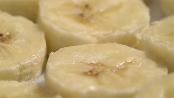 Banana Slices Closeup, Macro Food Summer Background, Fruits Top View. Rotate