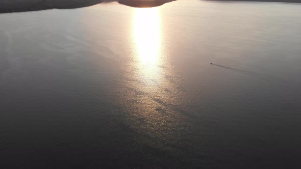 Aerial drone shot: motorboat floating the huge river.