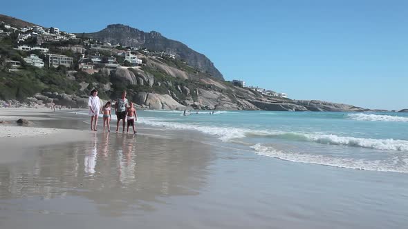 Family walking on beach and children running