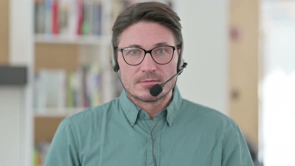 Middle Aged Man with Headset Looking at the Camera