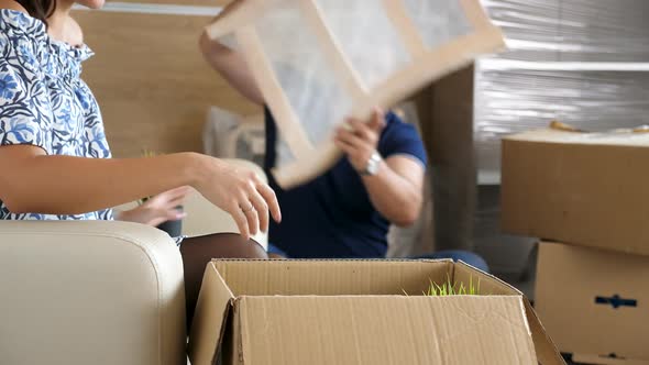 Man and Woman Unpacking From Cardboad Boxes