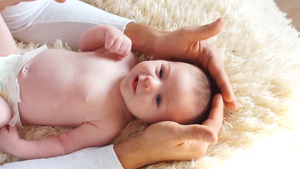 Young Father Having Cuddles on His Bed with His Baby Son.