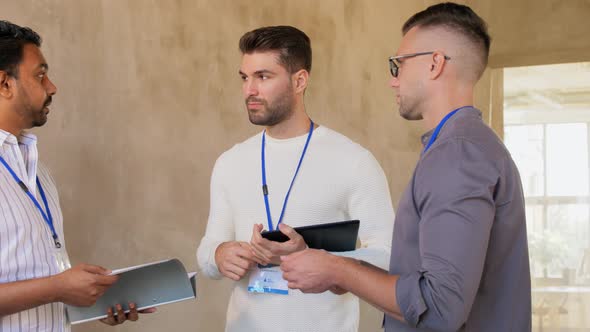 Businessmen with Name Tags Talking at Office