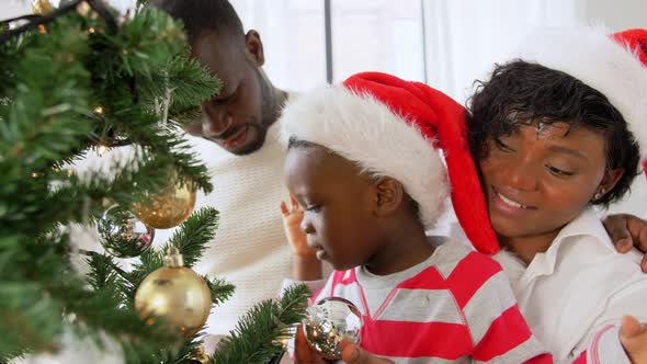 Happy Family Decorating Christmas Tree at Home