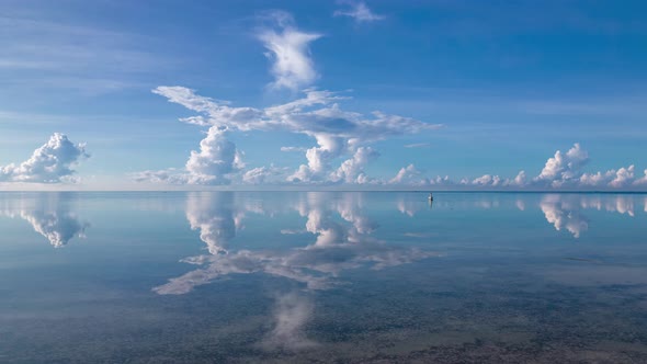 Drone flying low over waters of beautiful lagoon with stunning reflection of moving clouds. Hyperlap