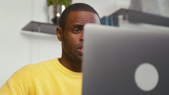 Smiling man calling with webcam at the desk at home office