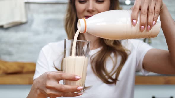 Close Up Hands of Adorable Girl Poured Liquid Dairy Beverage at Glassware