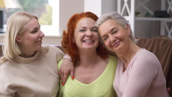 Happy Redhead Caucasian Woman Hugging with Friends Smiling Looking at Camera