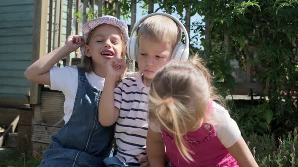 Portrait of Cute Little Three Children With Headphones Listening to Music