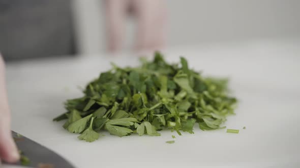 Curring vegetables on a white cutting board to cook vegetarian white bean soup.