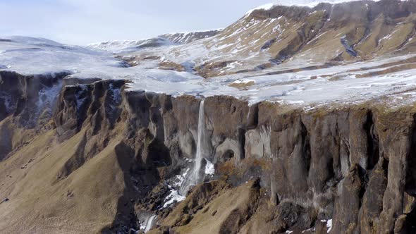 Small and Beautiful Waterfall on a Snowcapped Ledge in the Winter