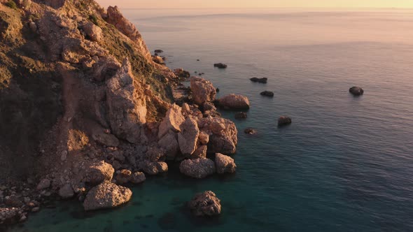 Blue Clear Water and Rocks of Tropical Island at Sunset