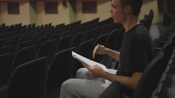 Caucasian high school teenage boy in the auditorium preparing for a performance