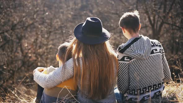 A Loving Family a Mother a Father and a Son Hugs While Sitting in Nature