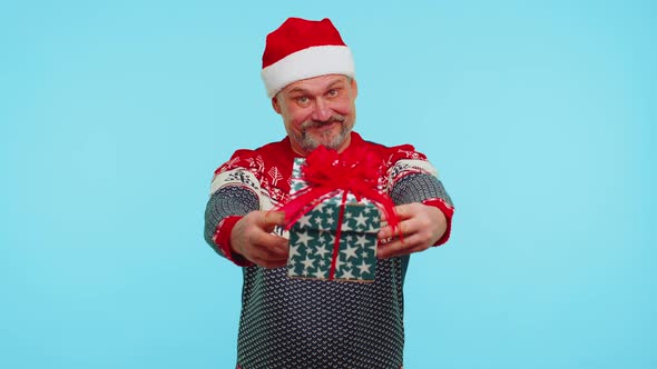 Funny Man Wears Red New Year Sweater and Hat Presenting Christmas Gift Box Shopping Sale Holidays