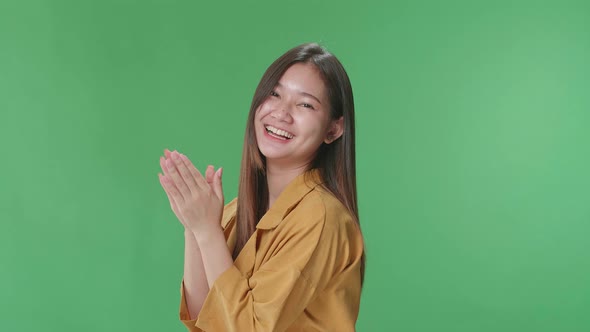 Young Asian Woman Clapping Her Hands In The Green Screen Studio