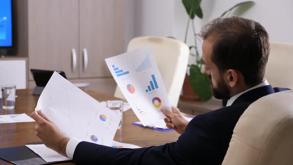 Businessman Looking at Charts and Graphs