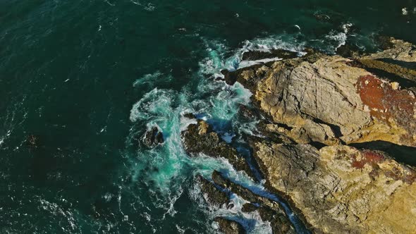 Aerial top view of ocean blue waves break on a coastline