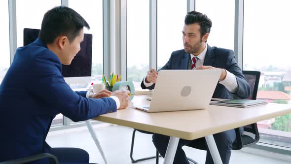 Two Business People Talk Project Strategy at Office