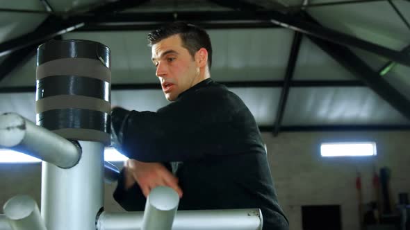 Kung fu fighter practicing martial arts with wooden dummy 4k