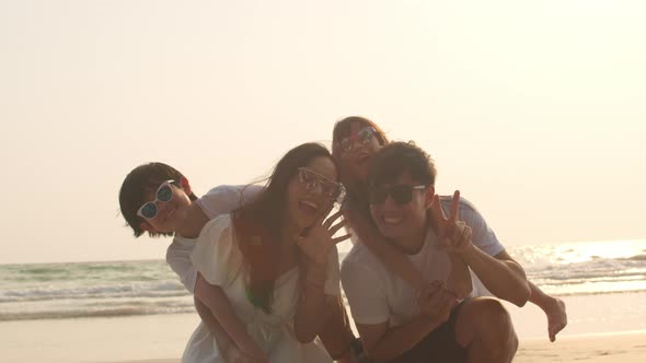 Dad, mom and kid set camera for take photo while relax together near sea when sunset.