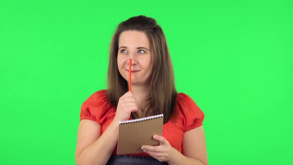 Portrait of Cute Girl Is Thinking, Then Happy Writing with Pencil in Notebook. Green Screen