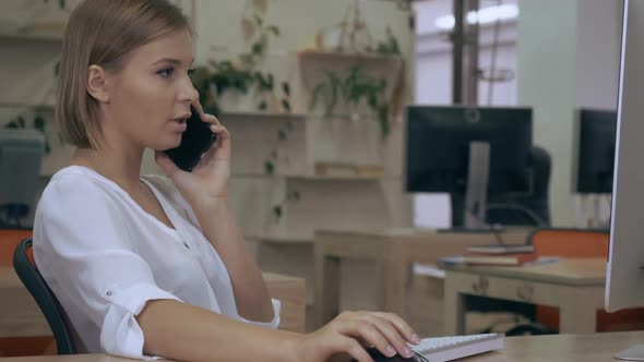 Businesswoman Has Phone Conversation in Office