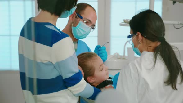 Dentists with Gloves and Mask Removes Tooth Decay Drilling Teeth