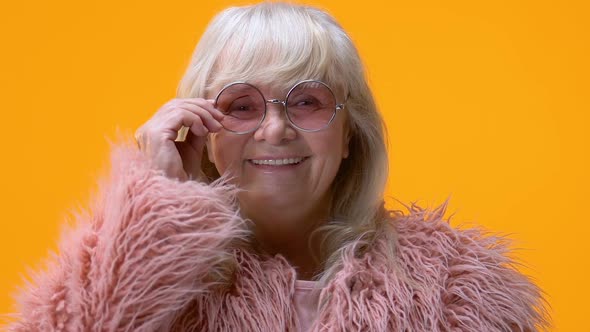 Fashionable Old Woman Taking Off Pink Glasses and Smiling in Camera, Happiness