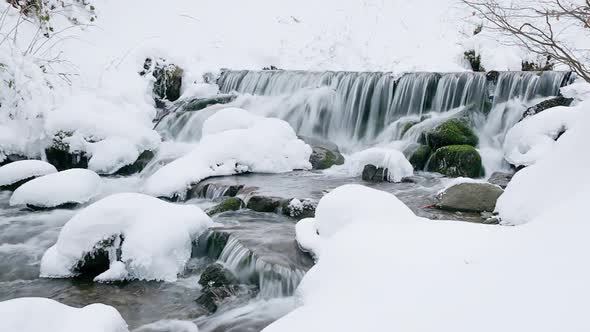 Wonderful Frozen Foot of a Waterfall with a Powerful Stream of Water at Winter Carpathian Mountains