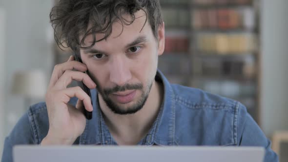 Negotiation By Casual Young Man While Talking on Phone