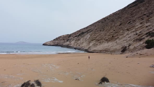 Woman walks on Gavdos Beach in Greece. Vacation concept. Aerial view