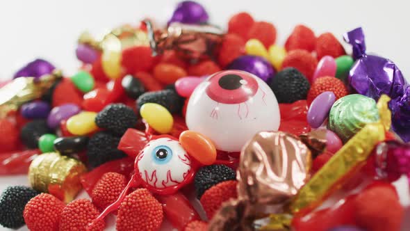 Close up view of variety of halloween candies fallen against grey background