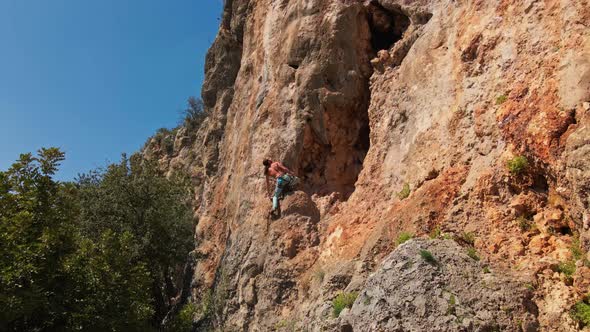 Drone Flying Out From Limestone Cliff with Rock Climber on It