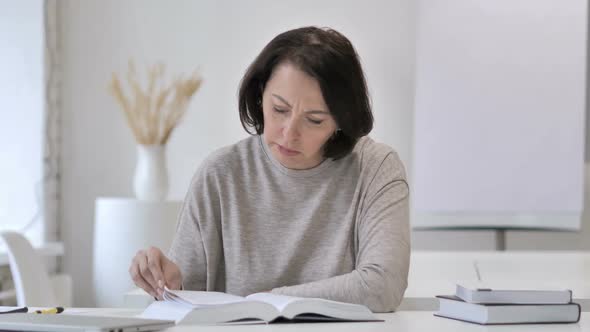 Old Senior Woman Reading Book in Office