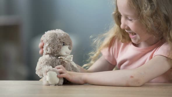 Joyful Blond Girl Playing With Teddy Bear and Laughing, Leisure Activity