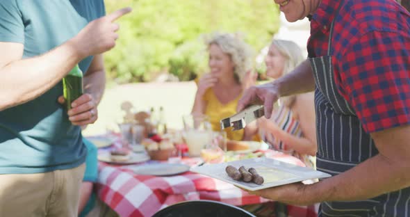 Happy caucasian family having barbecue and eating in garden