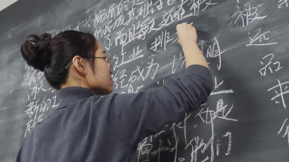 Chinese Woman Writing on Blackboard