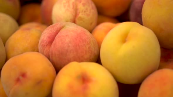 Close-up of Many Peaches on the Market. The Camera Is Moving. Slow Motion.