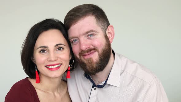 Portrait of a happy couple. Woman and bearded man smiling happily and lovingly at the camera